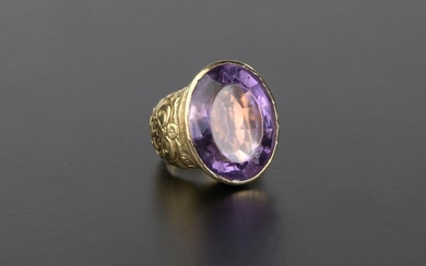 Ring in 18k yellow gold set with a large oval amethyst of mixed size, the shoulder decorated with chiseled crosses.