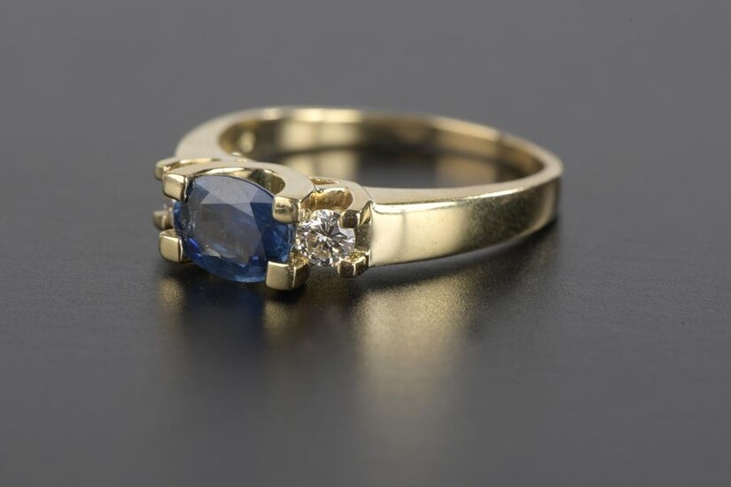 Ring in 18k yellow gold, set with an oval sapphire shouldered with small brilliant diamonds of about 0.15 ct.
