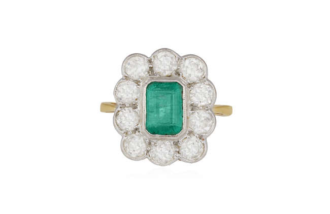 Description AN EMERALD AND DIAMOND CLUSTER RING, the cut-cornered...