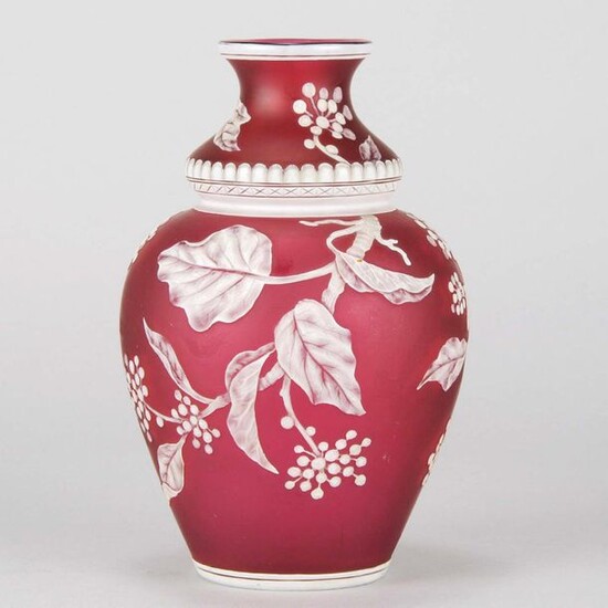English cameo glass vase attributed to Thomas Webb, decorated with a crisp white cameo cut floral pattern against a deep red field, unsigned. Circa 1900. Height 20 cm.