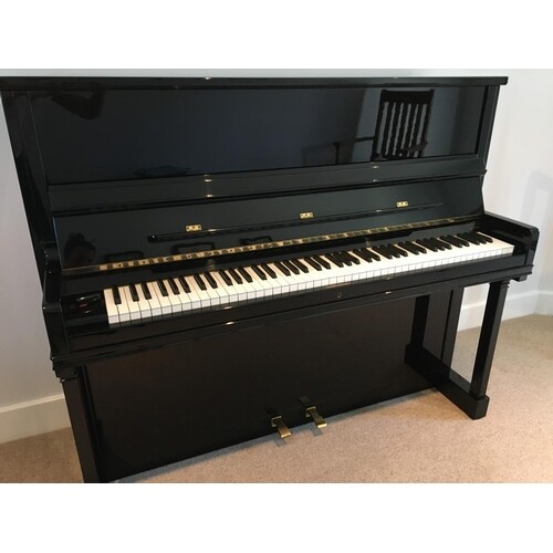 Feurich (c1980) An upright piano in a traditional bright ebo...