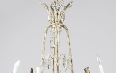 LUSTRE en bronze à décor de guirlandes de perles, fleurs et pampilles, à large couronne à huit bras de lumière. 81 x 66 cm. Accidents.