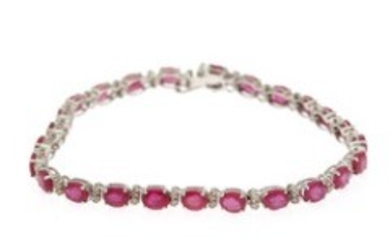 1918/1129 - A ruby and diamond bracelet set with numerous oval-cut rubies totalling app. 12.22 ct. and numerous single-cut diamonds, mounted in 18k white gold. L. 18.5 cm.