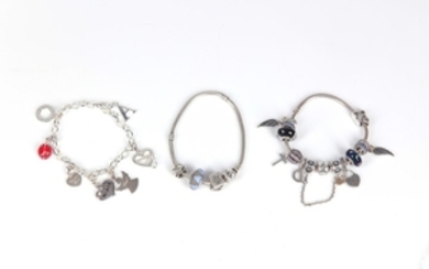 Three charm bracelets, including two by Pandora, suspending...