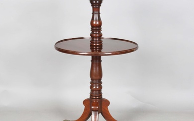 A 19th century mahogany circular two-tier dumb waiter, raised on tripod legs with brass caps and cas