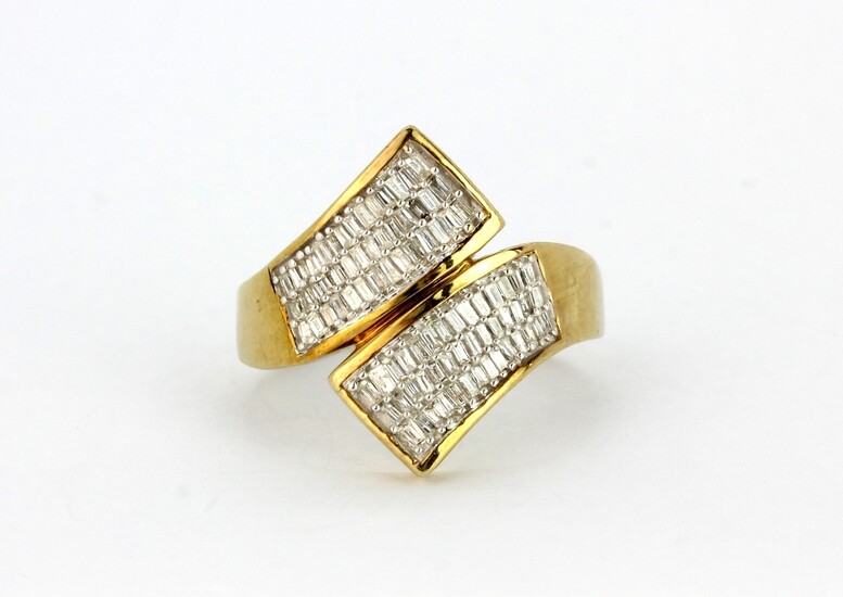 A 9ct yellow gold crossover ring set with baguette cut diamonds, (N.5).