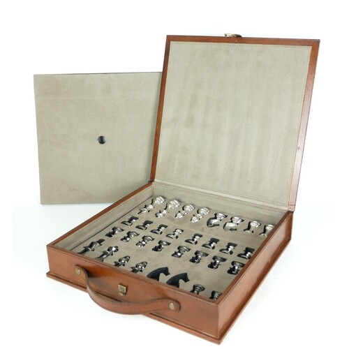A CASED LEATHER BOUND AND METALLIC CHESS SET The chrome fini...
