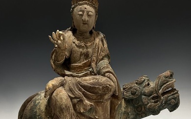 A CHINESE POLYCHROME WOODEN GROUP OF GUANYIN ON A MYTHICAL BEAST, MING DYNASTY OR EARLIER