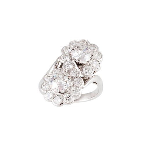 A DIAMOND DOUBLE CLUSTER RING, of cross over design, set wit...