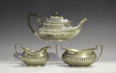 A George V silver half-reeded three-piece tea set, comprising teapot, two-handled sugar bowl and mil