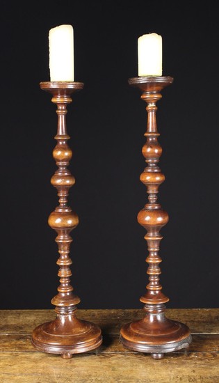 A Pair of Tall Turned Treen Candlesticks. The decorative multi-knopped stems rising from round mould