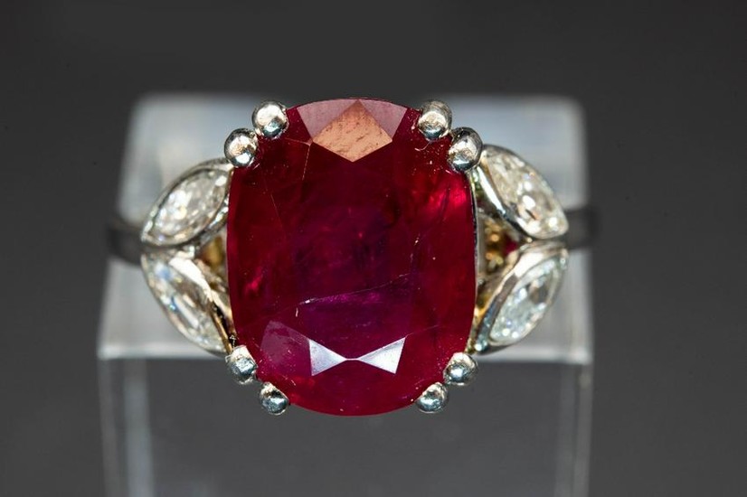A RUBY AND DIAMOND RING, the oval cut ruby set between