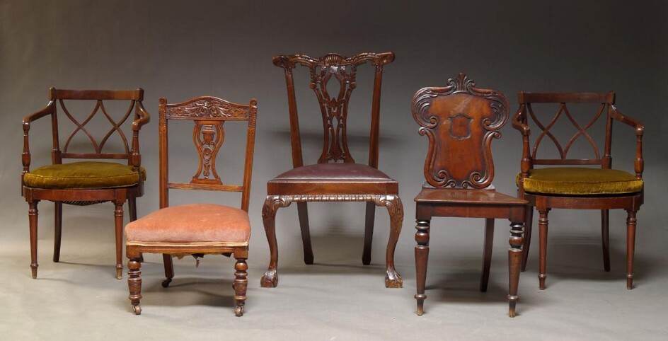 A Victorian mahogany hall chair, the backrest with carved scrolling foliate motifs, centred by a vacant cartouche, on front turned and tapering legs, together with pair of mahogany and caned armchairs, an Edwardian nursing chair and a Chippendale...