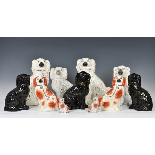 A collection of Staffordshire seated dogs, to include a whit...