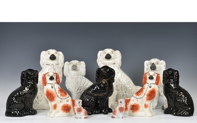 A collection of Staffordshire seated dogs, to include a whit...