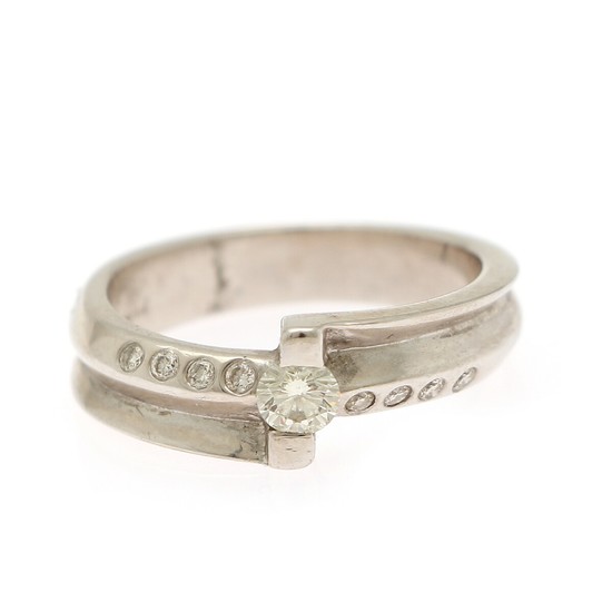 A diamond ring set with a brilliant-cut diamond weighing app. 0.20 ct. flanked by eight smaller brilliant-cut diamonds, mounted in 18k white gold. Size 53.