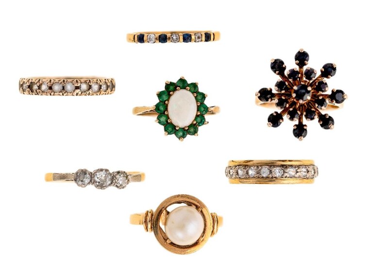 A group of seven gem-set rings, including a three stone diamond ring set with circular-cut diamonds, ring size R 1/2