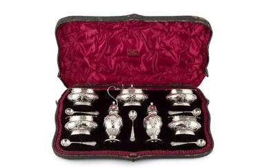 A late Victorian silver seven piece cruet set, with gadrooned...