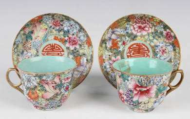 A pair of Chinese famille rose millefleurs porcelain cups and saucers, mark of Qianlong but probably
