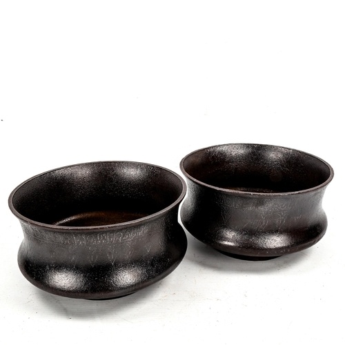 A pair of Islamic patinated iron ceremonial bowls, with reli...