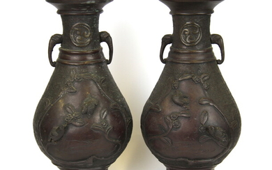 A pair of Japanese bronze vases decorated with panels of birds and with elephant head handles, H. 25cm.