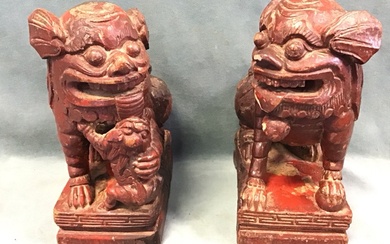 A pair of antique Chinese carved hardwood red lacquered dogs...