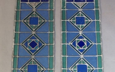 A pair of modern narrow stained glass panels, designed in green and blue glass with diamond motif to the panel, 105.5cm x 31.5cm each