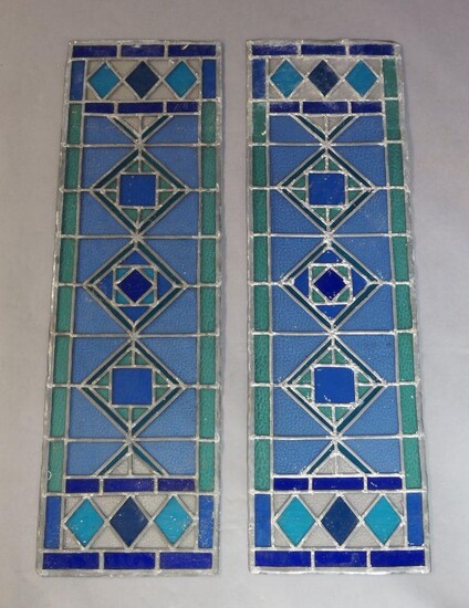 A pair of modern narrow stained glass panels, designed in green and blue glass with diamond motif to the panel, 105.5cm x 31.5cm each