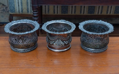 A pair of silver plated bottle coasters with foliate design, Height 11.5cm, together with one other with similar design