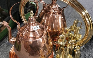 A pair of spiral brass candlesticks, a large copper kettle, a brass framed mirror and three further brass items.