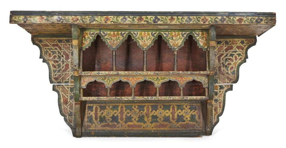 A polychrome painted wood shelving unit, Morocco or Spain, late 19th-early 20th century, decorated i n red, green and yellow with geometric designs and flowers, 80.5cm. high x 40cm. diam.