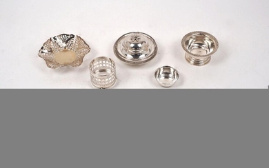 A small group of silver comprising: a Garrard & Co. Art Nouveau- style caddy spoon, Birmingham, 1997, designed with heart shaped bowl to short pierced stem; a pierced silver cruet mount, Birmingham, 1920, E S Barnsley & Co.; two pairs of silver...