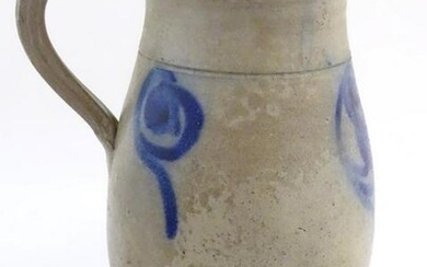 A studio pottery vase with a single handle and stylised