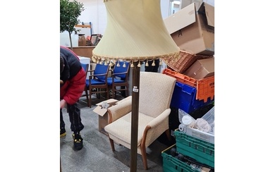 A vintage brass floor lamp with decorative base and claw fee...