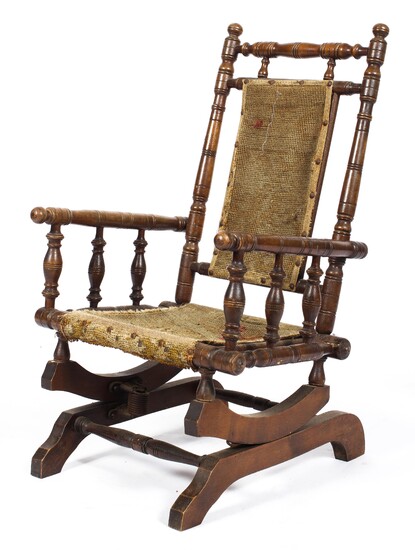 An Edwardian oak child's rocking chair, with turned reeded spindles and uprights