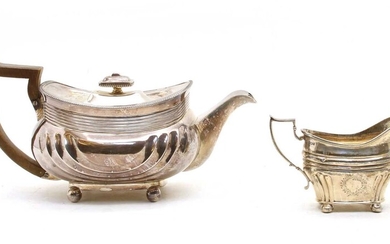 An Edwardian silver teapot and associated milk jug