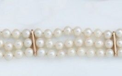 BRACELET trois rangs de perles de culture alternées de barrettes en or (750). Fermoir en...
