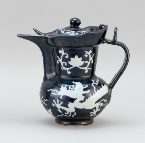 CHINESE WHITE-ON-BLUE PORCELAIN EWER In monk's-cap form, with a five-clawed dragon and lotus design. Six-character Ming mark on base..