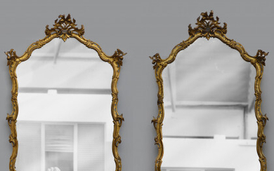 Coppia di specchiere di forma mossa in legno intagliato e dorato a volute fogliate e fiori (cm 140x98) (difetti)