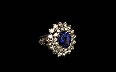 Flower RING in white gold centered with an oval-cut sapphire...