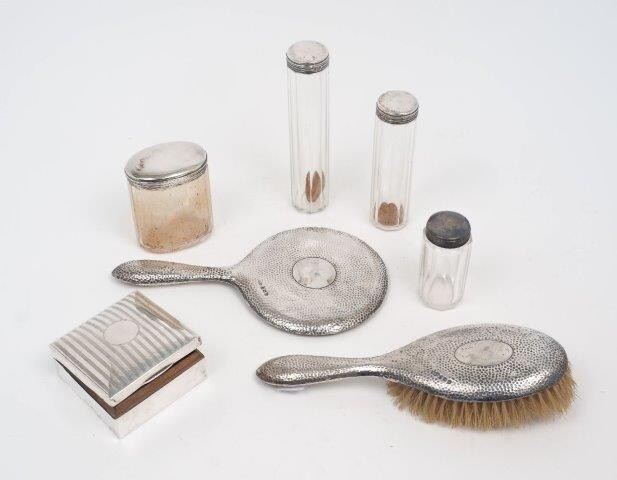 Four silver mounted vanity jars, London, 1911, WG, together with a square silver cigarette box, Birmingham, 1922, maker's mark rubbed, the box with striated design to lid, 8.5 x 8.5cm; and a silver mounted hairbrush and hand mirror, Birmingham...