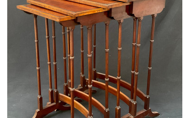 Gruppo di quattro tavolini a nido lastronati in legni vari, piani profilati in legno ebanizzato, gambe intagliate a finto bamboo...