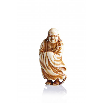 Ivory netsuke of Daruma, the Buddhist patriarch standing on reeds in a reference to his journey across the Yangtze river...