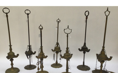 Lotto composto da sette lampade fiorentine in bronzo con coppa a tre fiamme, di cui cinque con accessori. Presa ad...