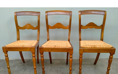Lotto di tre sedie in legno intagliato, schienale a giorno, gambe anteriori tornite e posteriori a sciabola (difetti)