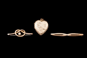 TWO ANTIQUE BROOCHES; together with a heart shaped locket