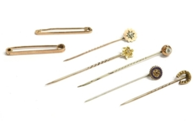 A collection of gold stick pins and two bar brooches
