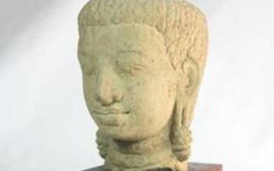 A Cambodian carved stone head, mounted on a wooden stand, 26.5cm overall.