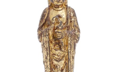A Chinese gilt copper alloy figure of Guanyin, standing on a lotus...