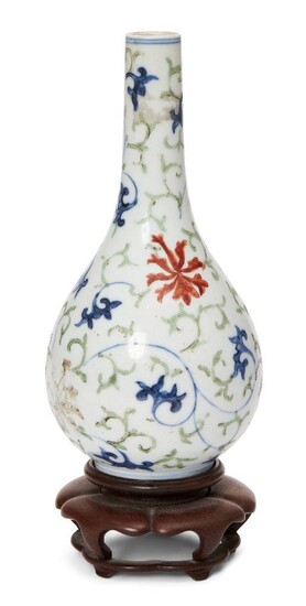 A Chinese porcelain doucai bottle vase, early 18th century, painted in doucai enamels with lotus flowers and meandering leafy scrolls, apocryphal Wanli mark to base, 15cm high, wood stand